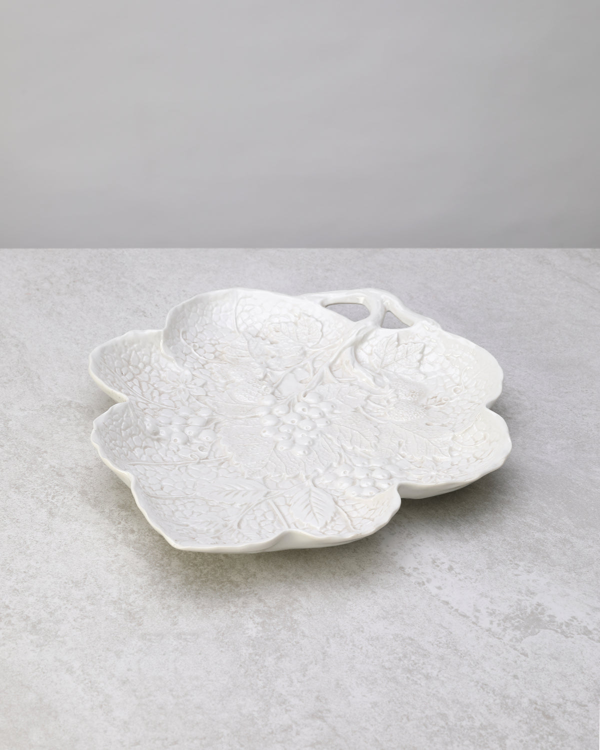 White glazed porcelain leaf-shaped plate with an embossed pattern, on white
