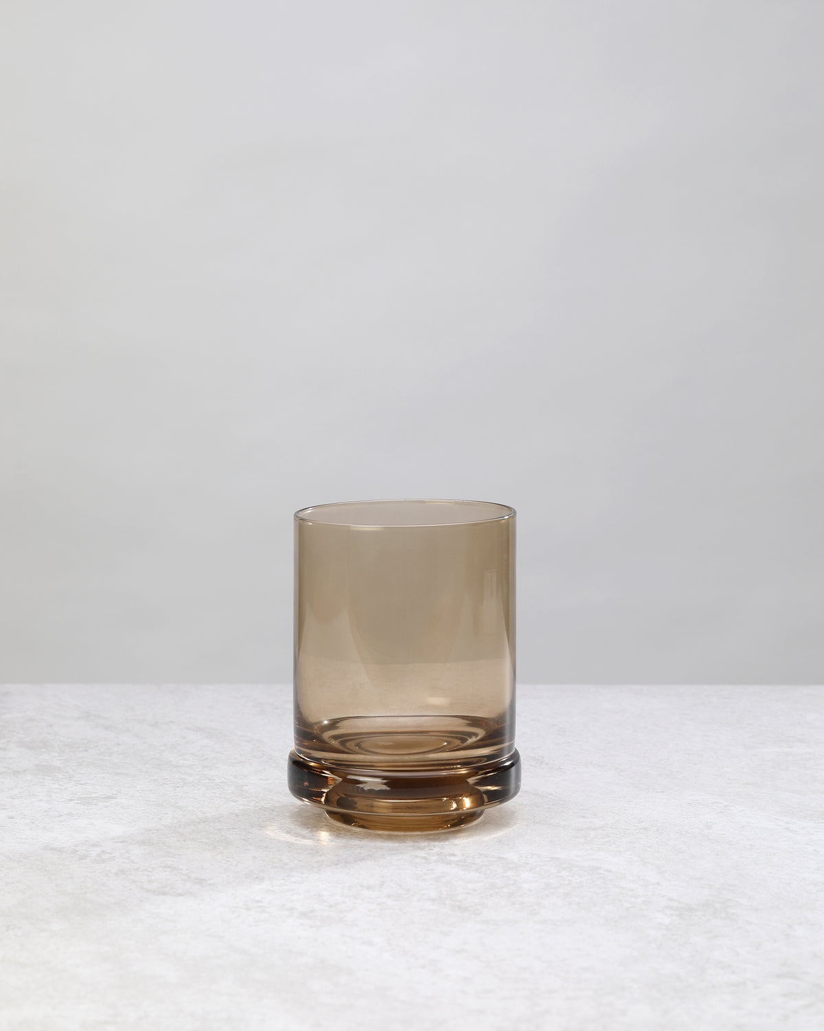 Single coffee-brown tumbler glass, front view