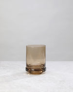 Single coffee-brown tumbler glass, front view