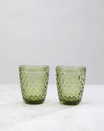 Two olive green small diamond tumbler glasses with an all-over diamond pattern, on white