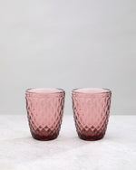 Pair of pink small diamond tumbler glasses on a white background