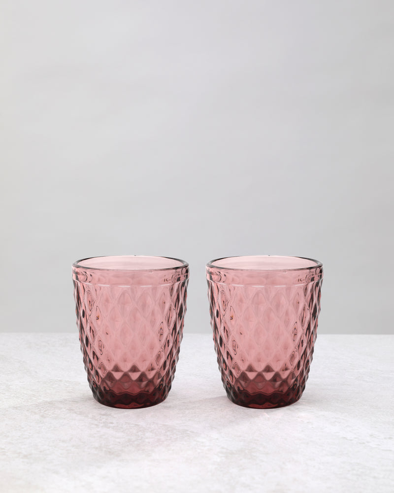 Pair of pink small diamond tumbler glasses on a white background