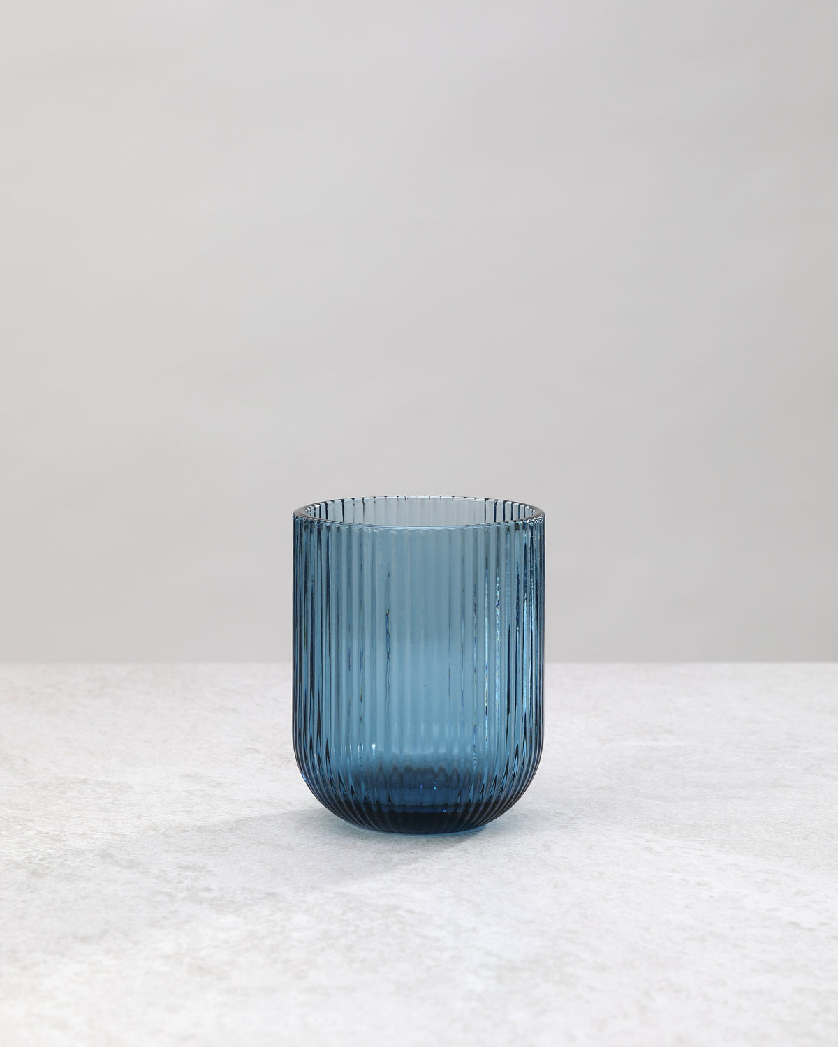 Single blue ribbed tumbler glass showing the fine vertical ribs