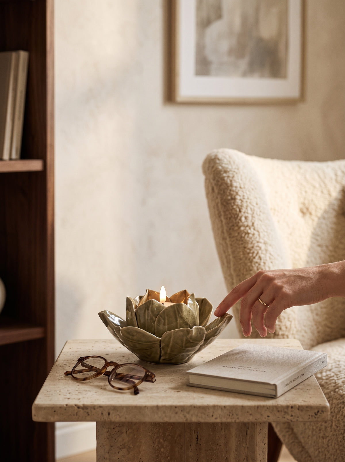 Hand setting the green lotus tea light holder on a side table