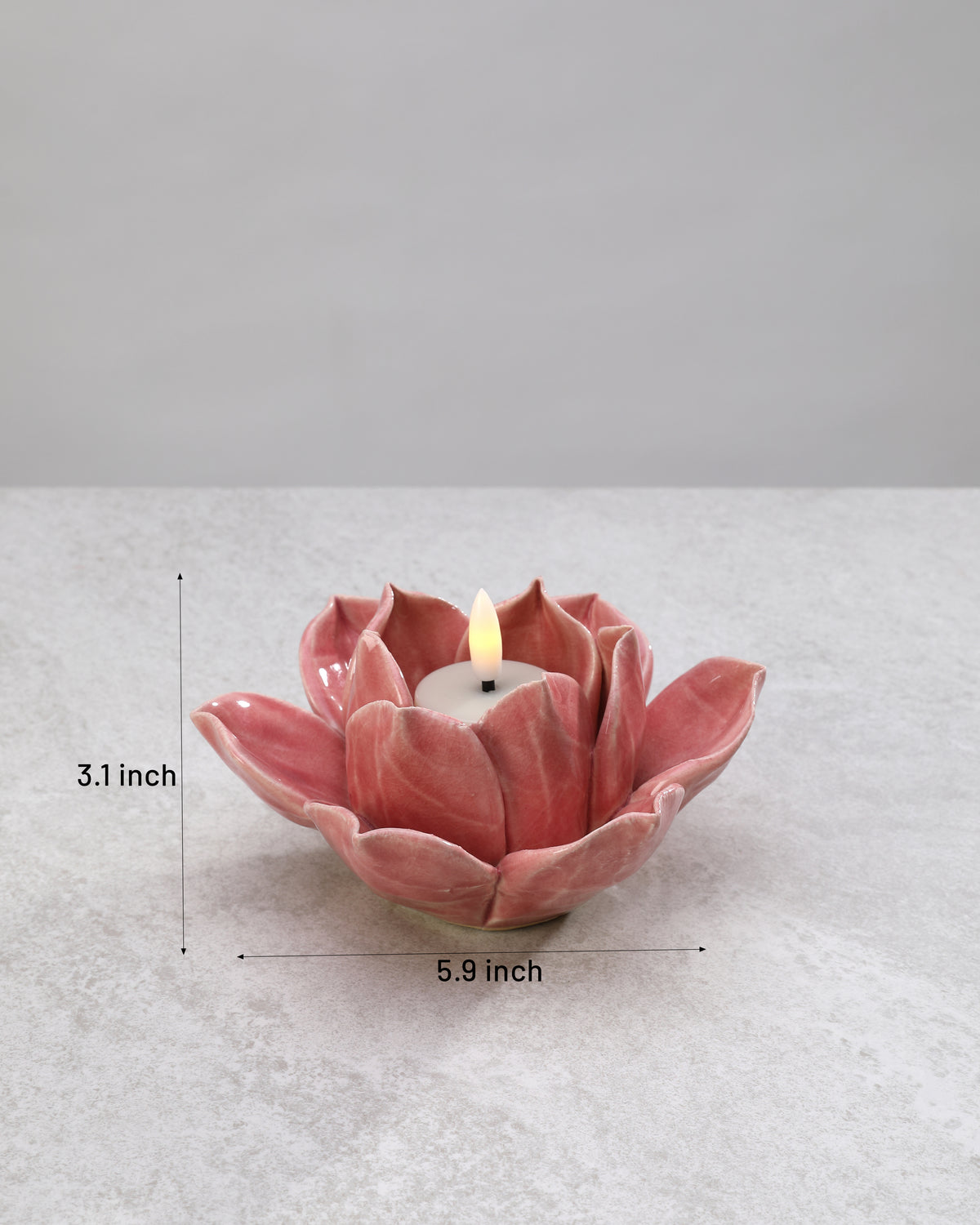 Pink ceramic lotus tea light holder with its dimensions marked