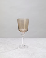 Single coffee-brown wine glass on a clear stem, front view