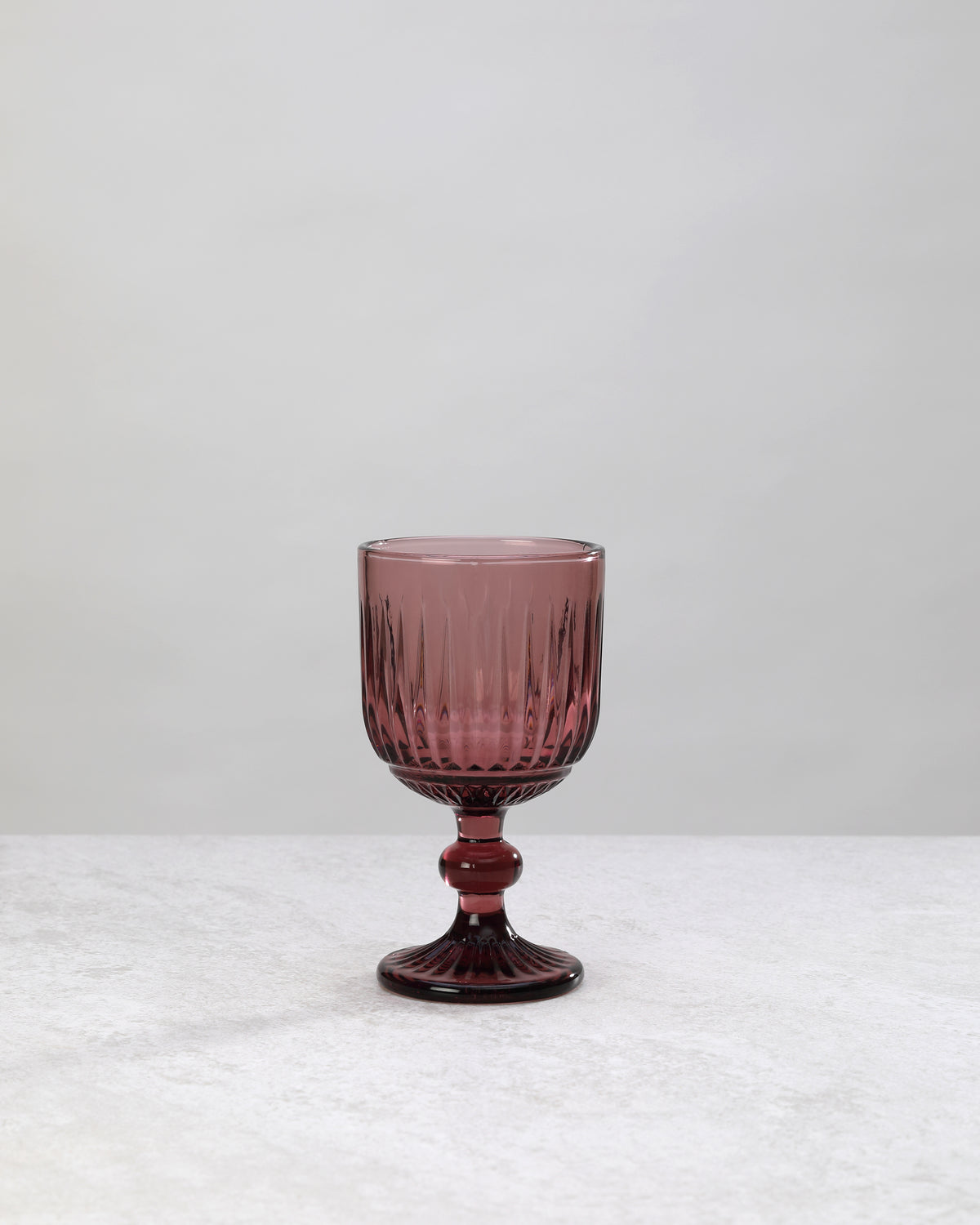 Single burgundy ribbed cut wine glass, front view