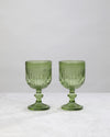 Pair of green ribbed cut wine glasses on a white background