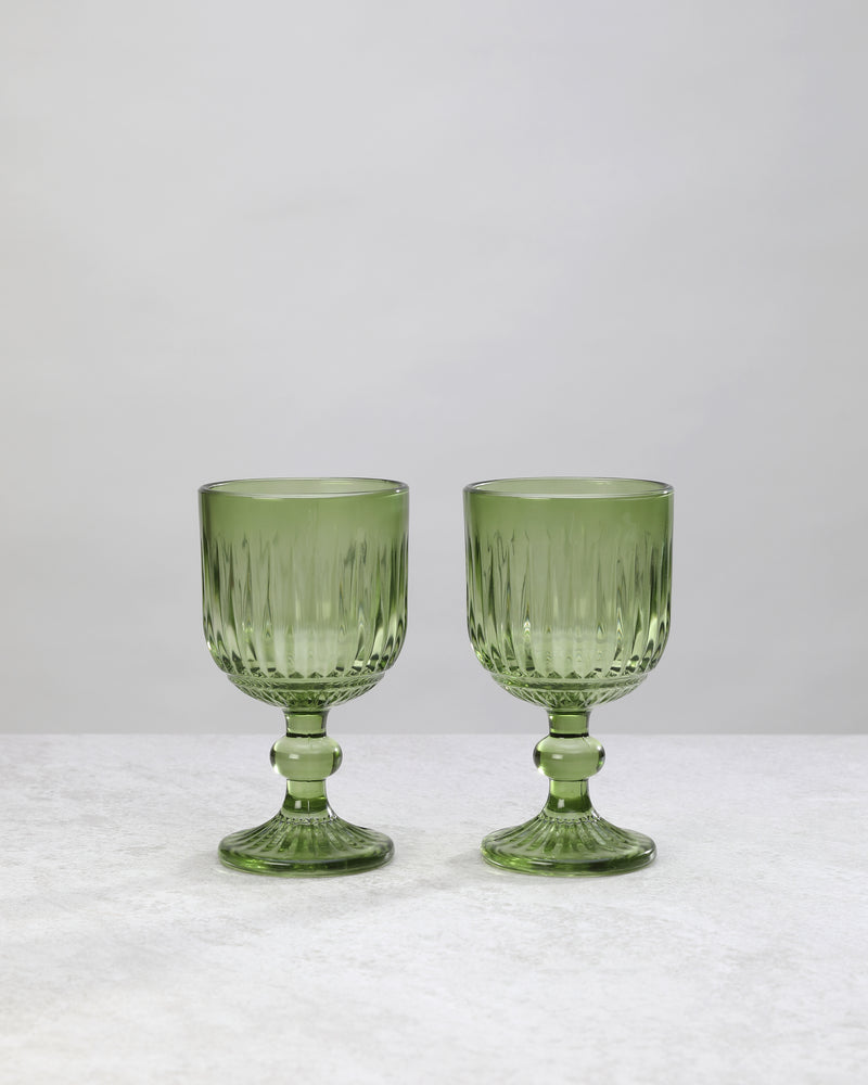 Pair of green ribbed cut wine glasses on a white background