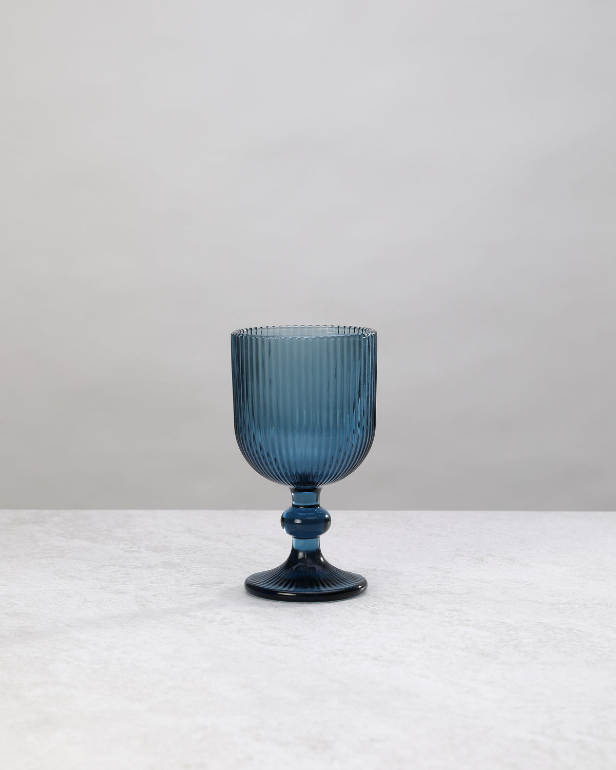 Single blue ribbed wine glass, front view