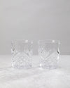 Pair of clear machine cut whiskey glasses on a white background