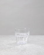 Single clear water glass showing the faceted base