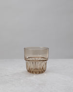 Single amber water glass showing the faceted base