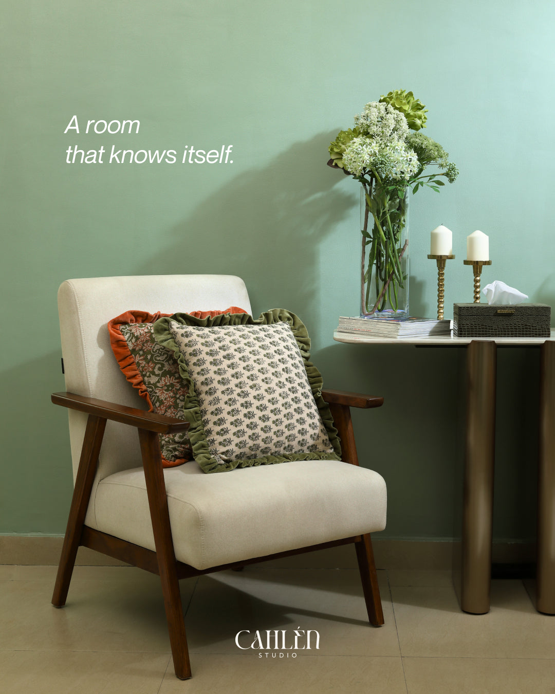 Cream armchair with patterned cushions beside a side table with flowers