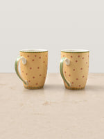 Back view of two Mor Bagh Dawn coffee mugs with a scattered dot pattern and green handles