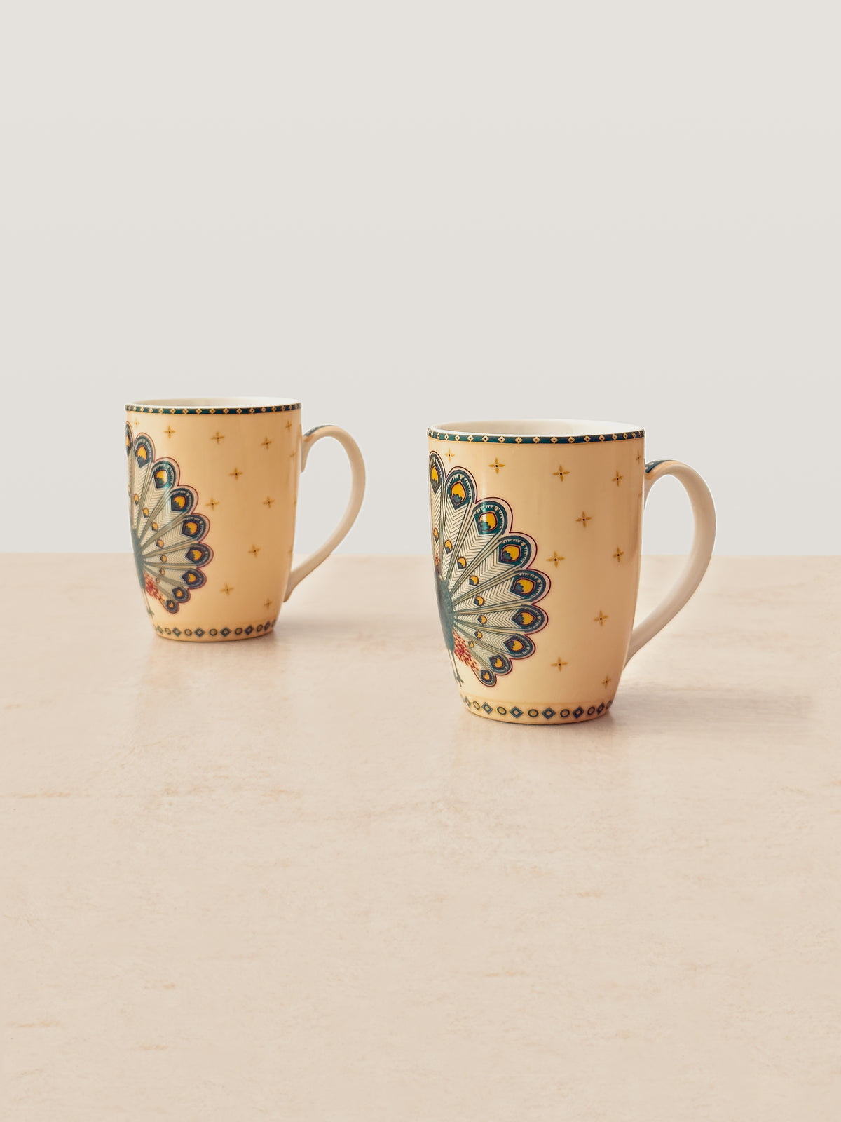 Pair of Mor Bagh Dusk coffee mugs on a stone counter, handles facing right