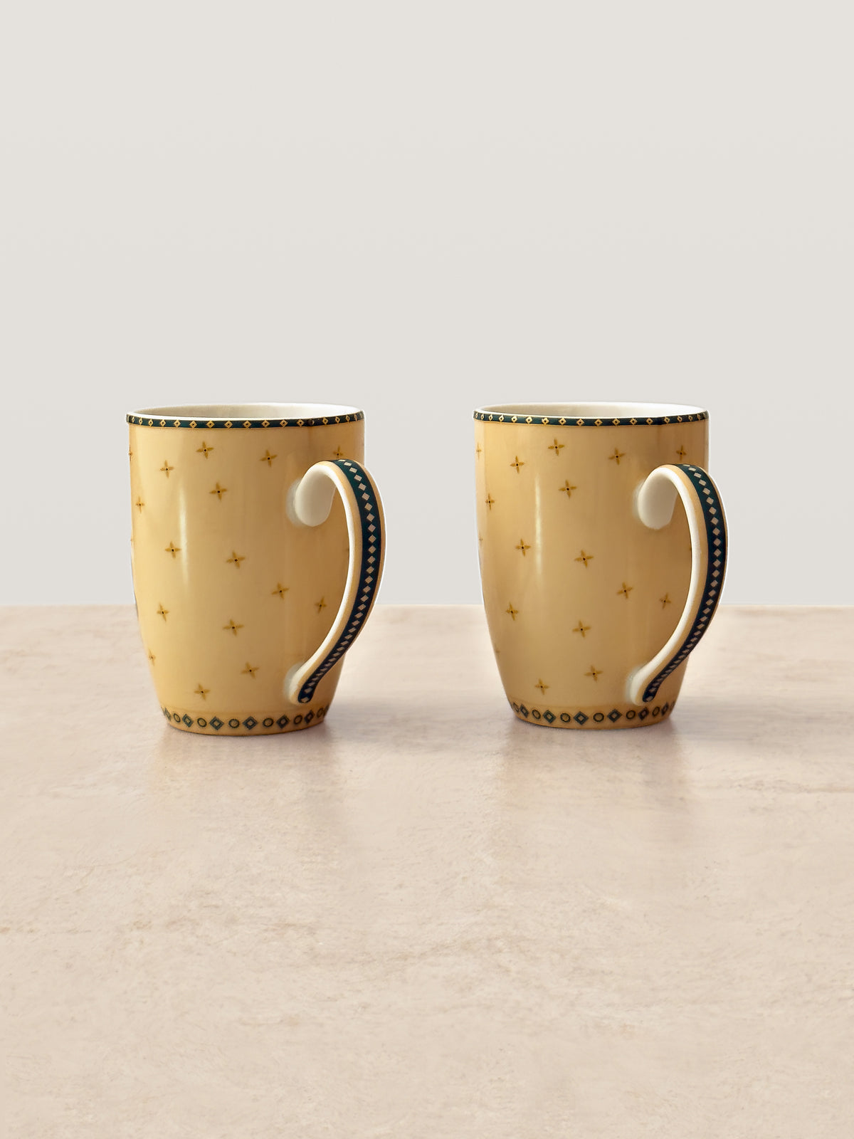 Back view of two Mor Bagh Dusk coffee mugs with dotted pattern and dark green handles