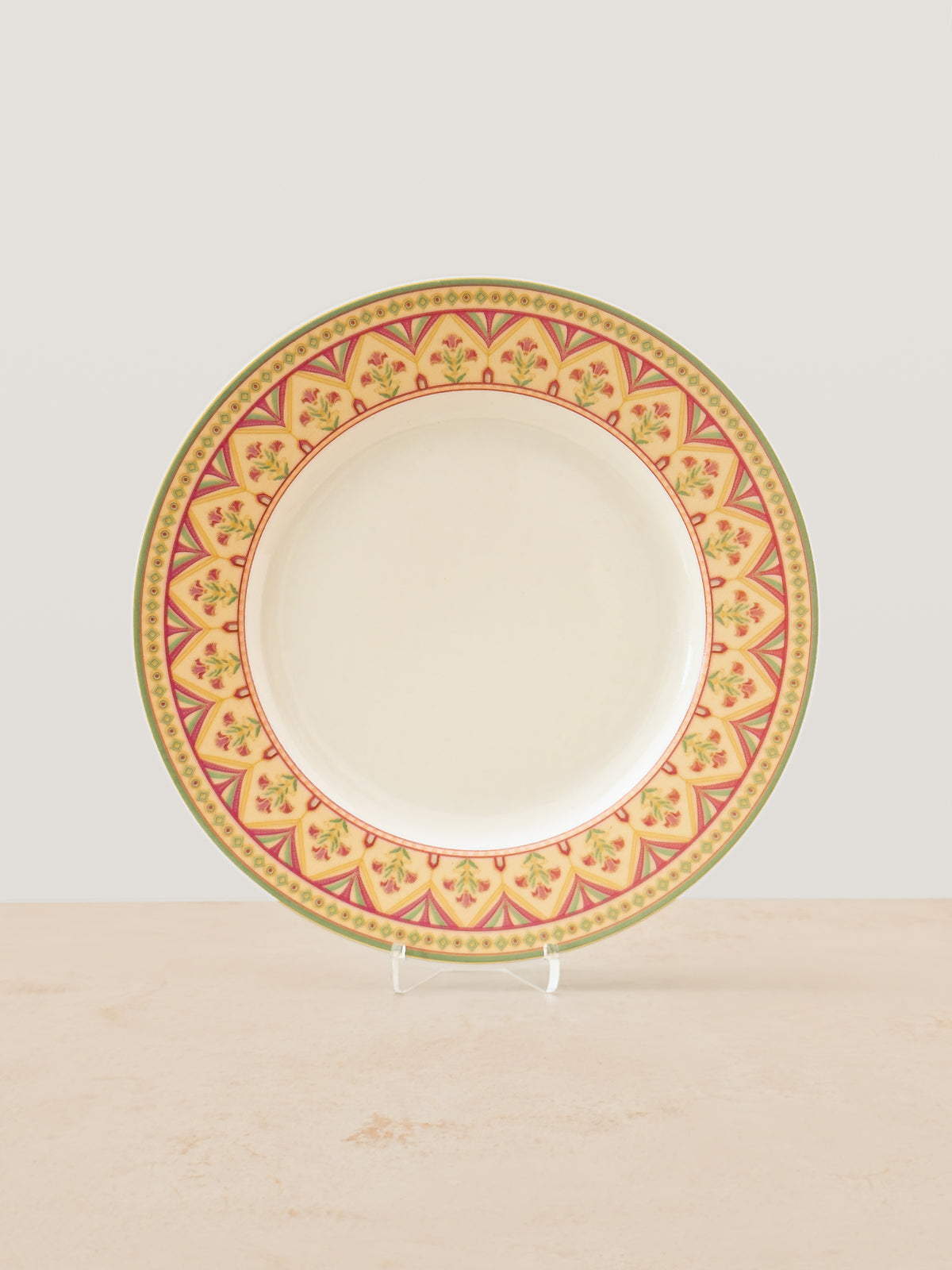 Mor Bagh Dawn porcelain dinner plate on a stand, wide pink and gold patterned rim with a plain centre