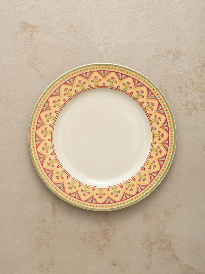 Mor Bagh Dawn dinner plate from above, showing the pink and gold border on a stone background