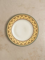 Mor Bagh Dusk dinner plate from above, gold border edged in dark green on a stone background