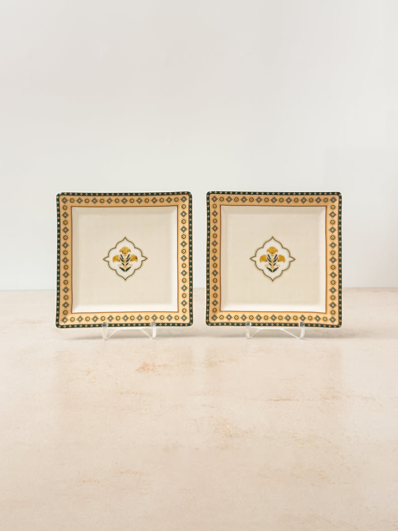 Two Mor Bagh Dusk porcelain square platters on stands with a gold border and centre motif