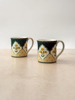 Pair of Mor Bagh Dusk tea mugs side by side on a stone surface, handles facing out