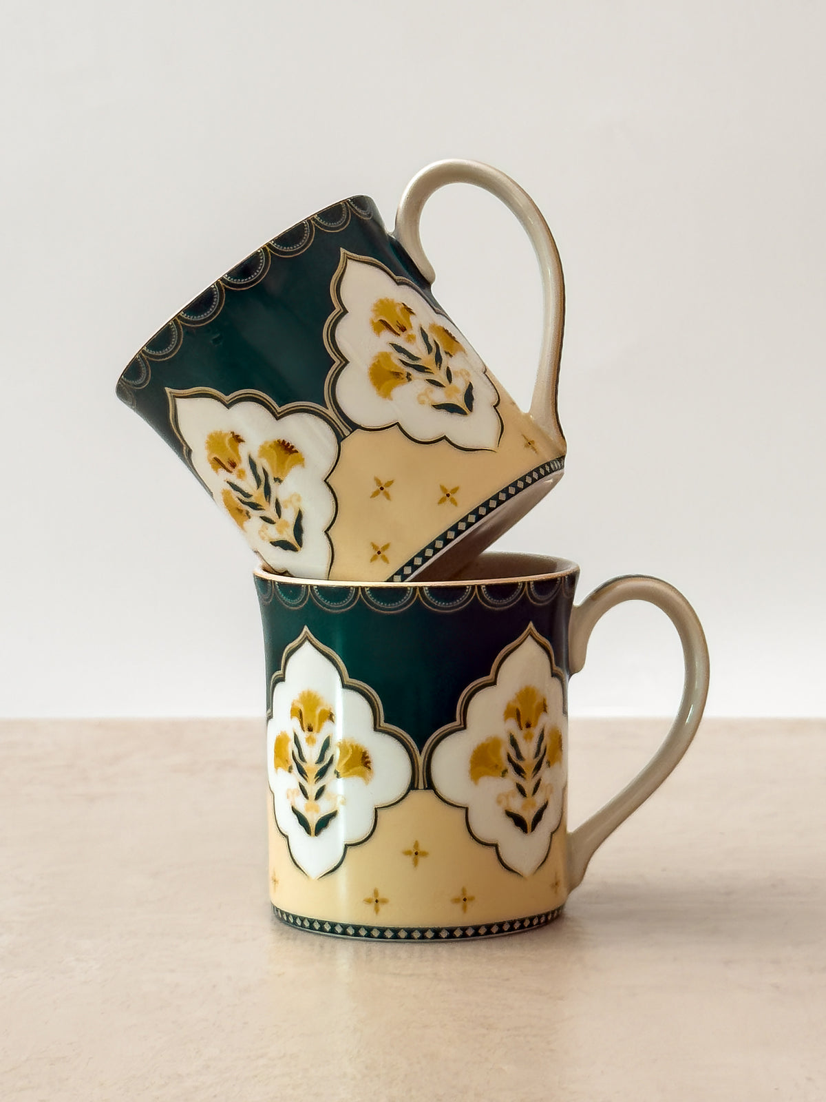 Mor Bagh Dusk porcelain tea mugs stacked, showing the dark green print and lotus motif