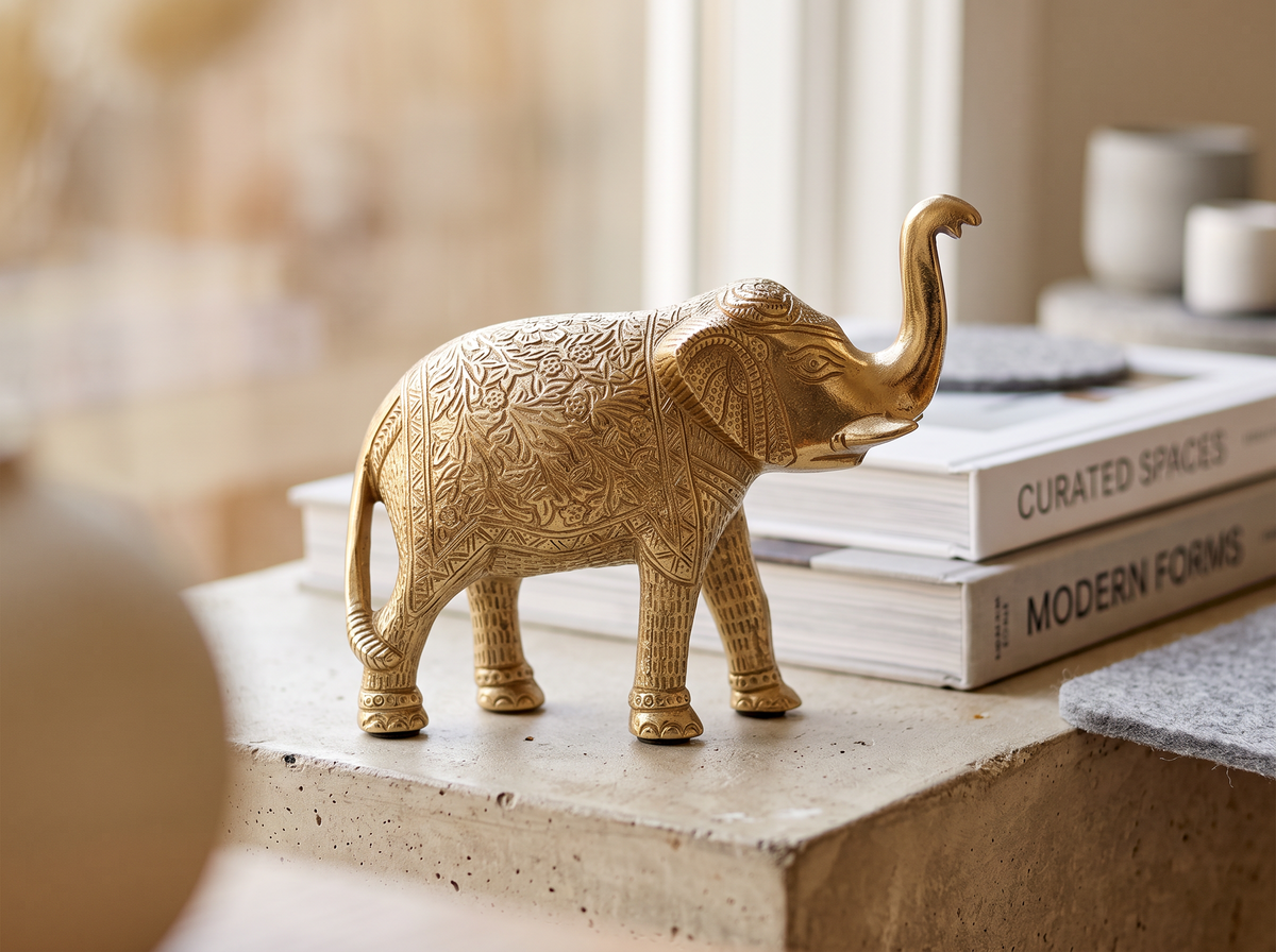 Tall gold elephant figure on a stack of books on a shelf
