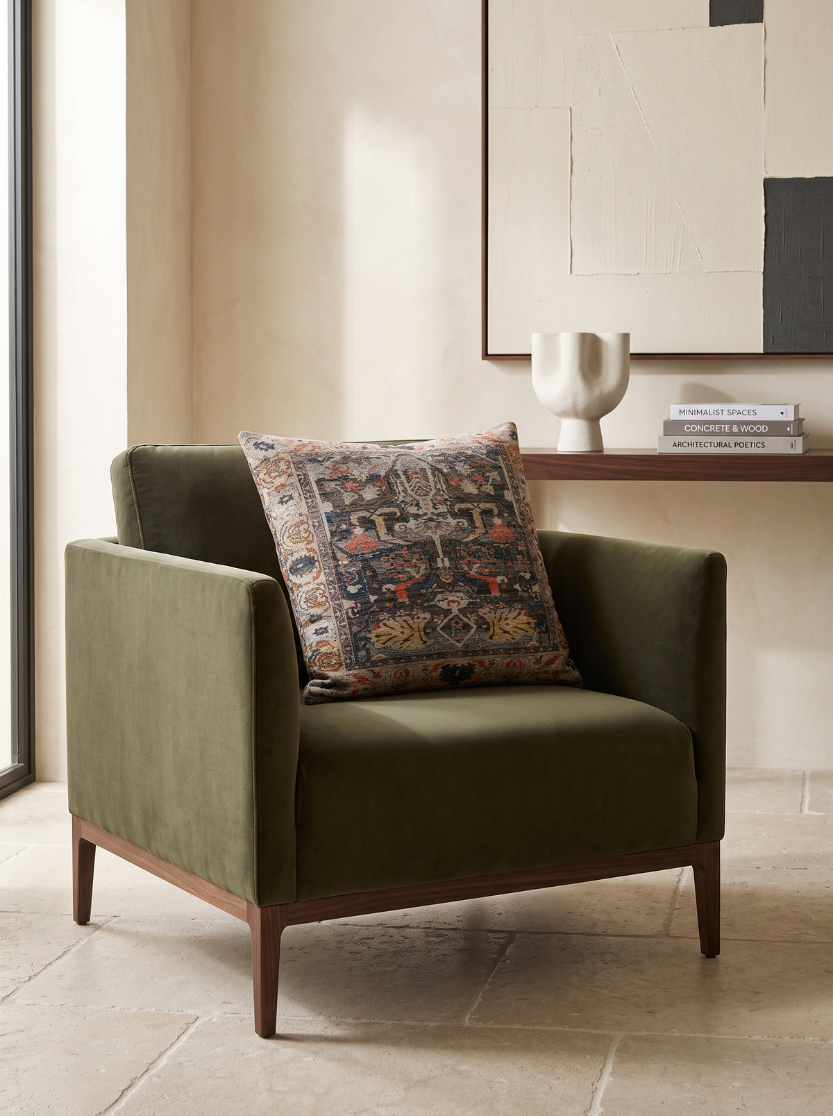 Black slub print cushion on an olive green velvet armchair