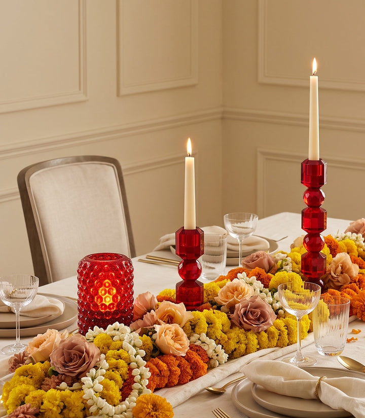 Festive dining table lit with bubble glass lights, candles and marigolds