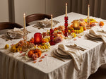 Ruby red crystal candle holders lit on a long dining table dressed with marigolds for a festive meal