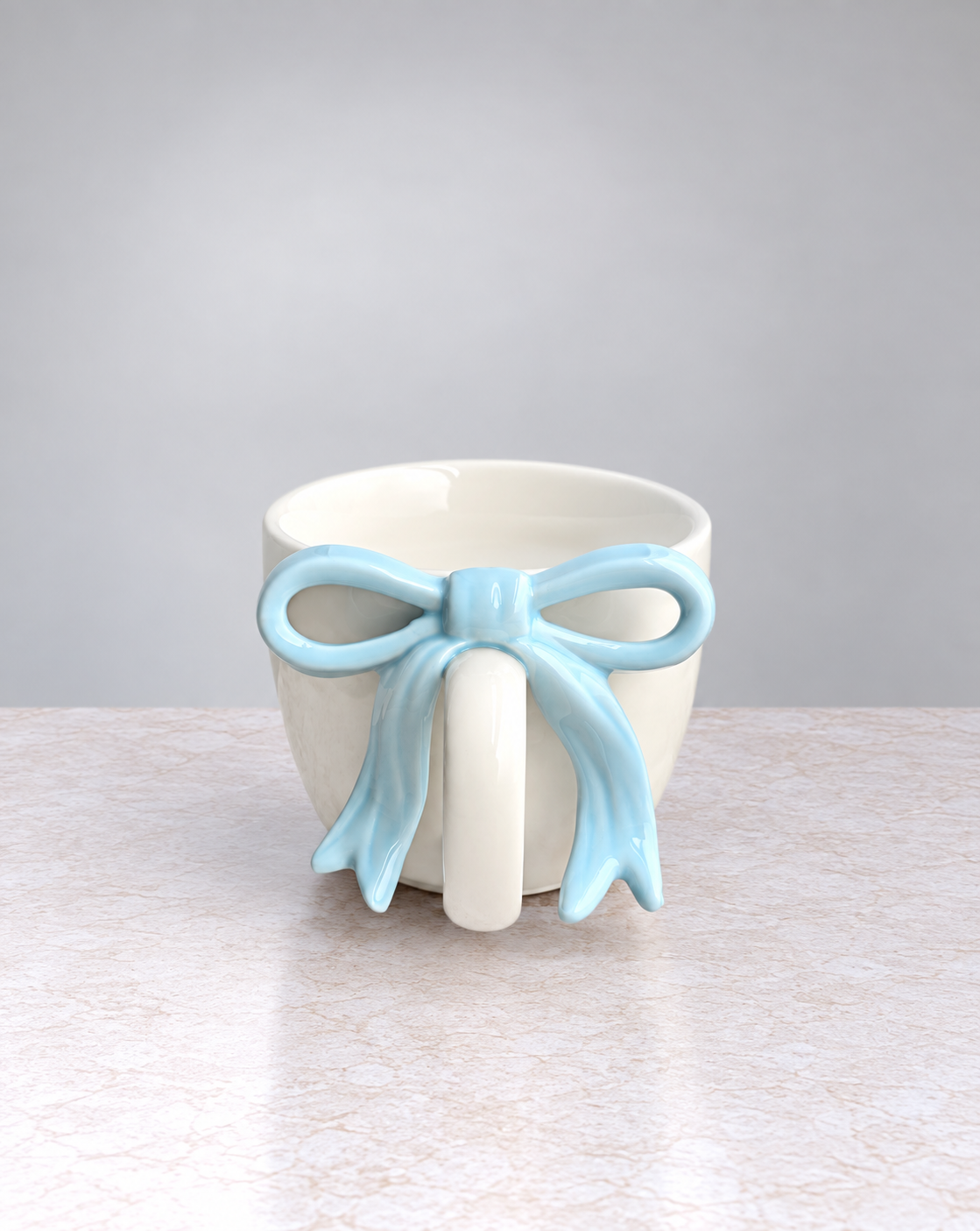 Powder blue ribbon bow ceramic mug, front view of the bow