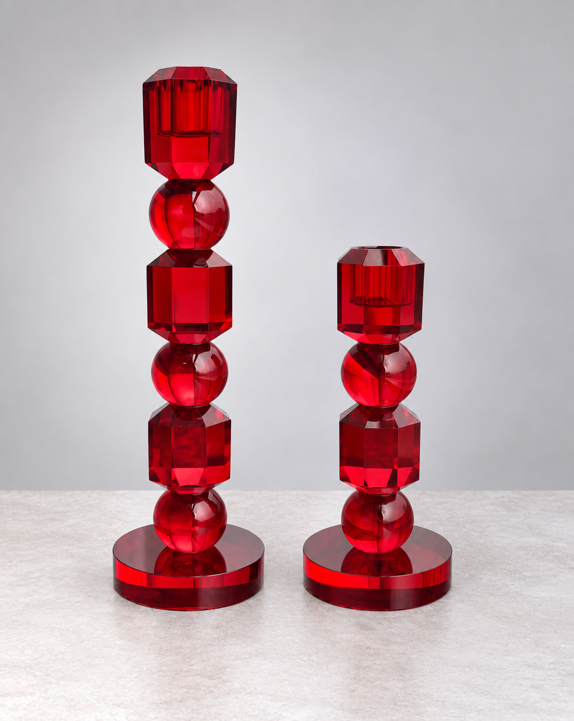 Large and small ruby faceted crystal candle holders side by side to show their heights